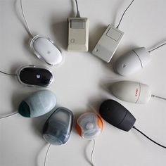 several computer mouses sitting in a circle on top of a white table with cords