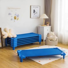 a room with blue furniture and pictures on the wall, including a baby's crib