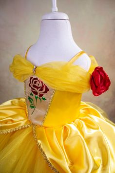 a dress made to look like a princess with a rose on the chest and shoulder