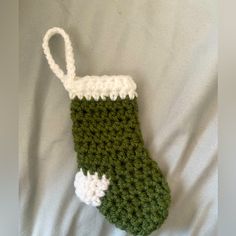 a green and white crocheted stocking laying on top of a bed