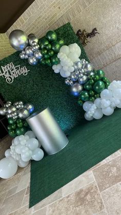 a green and white birthday decoration with balloons