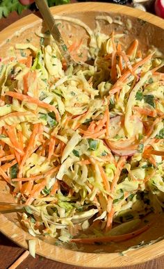 a wooden bowl filled with coleslaw and carrots