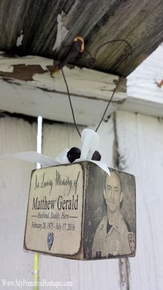 an ornament hanging from the side of a building with a photo on it