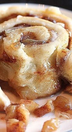 cinnamon rolls on a plate with syrup drizzled all over the top and bottom