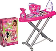 a pink ironing board with minnie mouse on it next to a box and toy