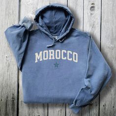 Morocco Comfort Colors® Crewneck Pullover to Embrace the Essence of Morocco this Christmas with Cozy Holiday Apparel - Plus Size Too Perfect Holiday, Thanksgiving, Christmas or Birthday gift for your special someone - especially you! This stylish, unisex, garment-dyed hoodie, is made with 80% ring-spun cotton and 20% polyester. Each Comfort Colors® hoodie sweatshirt features garment-dyed, ring-spun fleece with a 100% cotton face, while the hood is jersey-lined with a color-matched flat cord. It also has a rolled-forward shoulder and a back neck patch. * Luxurious Feel - the fabric is soft and pleasant to touch, and has a subtle luxurious feel. Made from specially spun fibers that make very strong and smooth fabric. * Hooded - with drawstrings, and the hood is lined with jersey fabric with Luxury Blue Sweatshirt With Drawstring Hood, Luxury Garment-dyed Hoodie Sweatshirt, Cord Ties, Holiday Apparel, Shirt Detail, Cozy Holiday, Thanksgiving Christmas, Holiday Outfits, Jersey Fabric