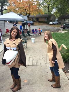 two women dressed in costumes standing on the sidewalk