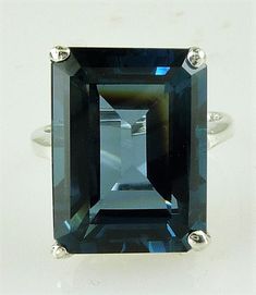 ALL OUR JEWELRY IS HANDCRAFTED IN U.S.A. Lovely as the clear, radiant blue of island seas... This exquisitely emerald cut London Blue Topaz is of rare great size not seen in a London Blue Topaz a full 29.51 carats-- catching the light and dazzling your friends. This ring is sure to capture the attention of many admiring glances. And this great traditional design of the setting perfectly complements this great stone. Set in solid 10kt white gold. You will love it... London Blue Topaz, (1) 20x15mm Types Of Diamond Cuts, Emerald Cut Ring, Precious Stones Rings, Vintage Jewellery Rings, Emerald Cut Rings, London Blue Topaz Ring, Wedding Rings Solitaire, Types Of Diamonds, Blue Topaz Stone