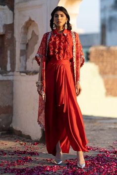 Ruby red cape with feather print and pearl, dori embroidered cutwork border. Paired with ruffle shirt and draped skirt.
Components: 3
Pattern: Printed, Embroidery
Type Of Work: Feather, pearl, dori
Neckline: Cape: Open, Shirt: Spread collar
Sleeve Type: Flared sleeves
Fabric: Flat Chiffon, Dola Silk, Organza
Color: Red
Other Details: 
Cutwork border
Lace embroidered panel
Occasion: Sangeet - Aza Fashions Red Draped Dupatta Set, Red Draped Sets With Dupatta, Red Draped Set With Dupatta, Bohemian Draped Sets For Festive Occasions, Designer Red Ruffled Sets, Bohemian Red Set With Sheer Dupatta, Bohemian Red Sets With Sheer Dupatta, Festive Red Sets With Cape Sleeves, Red Designer Sets With Cape Sleeves