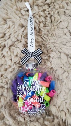 a glass ornament filled with lots of colorful beads on top of a furry surface