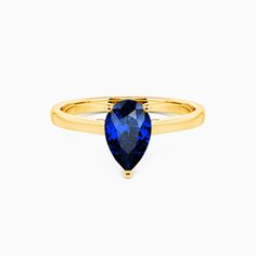 a yellow gold ring with an oval blue sapphire stone set in the center, on a white background