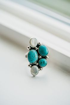 The Ellen ring, officially my new favorite ring on our website! Uniquely shaped and even prettier in person! Turquoise stones Mother of Pearl Shell stones Silver dot detailing Dark oxidation to make the stone colors pop Flattering and feminine shape Sterling silver Sterling Silver Turquoise Ring With Stones, Turquoise Sterling Silver Ring With Accent Stones, Sterling Silver Turquoise Ring With Accent Stones, Blue Turquoise Ring With Sterling Silver, Blue Turquoise Sterling Silver Ring With Stones, Turquoise Gemstone Moonstone Ring, Elegant Turquoise Moonstone Ring In Sterling Silver, Turquoise Rings With Accent Stones In Sterling Silver, Oval Turquoise Moonstone Ring In Sterling Silver