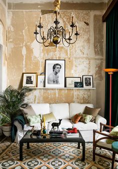 a living room filled with furniture and pictures hanging on the wall above it's coffee table