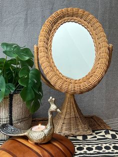 a mirror sitting on top of a table next to a potted plant and vase