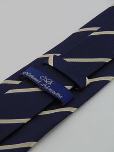 "This is a classic men's navy necktie with gold stripe. Available as a extra long Necktie Handmade from 100% silk, this special collection features a .75\" Eds Neckties logo at the bottom right front corner of every tie and a larger logo located on the tipping (Back of the tie). The label features the collection name (Nathaniel Alexandria) Named after my son Nathaniel and my daughter Alexandria. Expertly hand-made from 100% silk you can select your length from 57\" to 63\" (Great for taller Men) Classic Gold Tie For Formal Occasions, Classic Gold Tie And Suit Accessories, Dapper Gold Accessories For Black Tie Suit, Classic Gold Suit And Tie Accessories For Black Tie, Classic Gold Suit And Tie Accessories For Formal Events, Classic Gold Suit And Tie Accessories For Formal Occasions, Formal Fitted Gold Neckwear, Gold Fitted Neckwear For Formal Occasions, Luxury Gold Tie For Black Tie Events