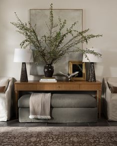 a living room filled with furniture and a table topped with a vase full of flowers