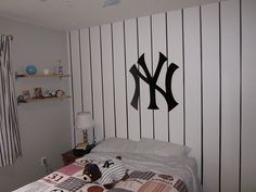 a baseball themed bedroom with the new york yankees logo painted on the wall above the bed