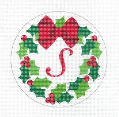 a cross stitch christmas wreath with red and green holly leaves, bells and a monogrammed letter j