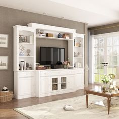 a living room filled with furniture and a flat screen tv on top of a white entertainment center