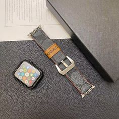 an apple watch sitting on top of a table next to a book and cell phone