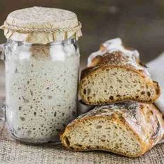 two loaves of bread sitting next to a jar of oatmeal