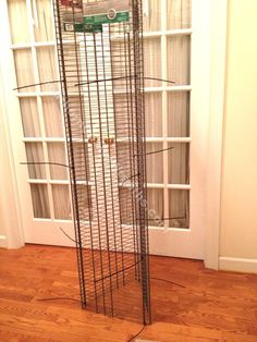 a tall metal tower sitting on top of a hard wood floor next to a window