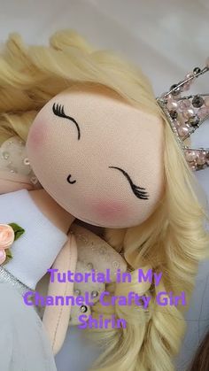 a doll with long blonde hair wearing a tiara and holding a flower in her hand