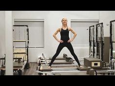 a woman is standing in the middle of an exercise room