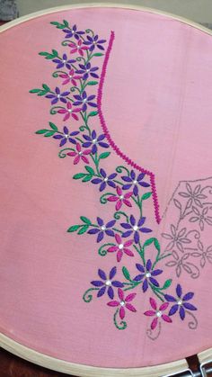 a close up of a embroidery on a piece of cloth with beads and flowers in it