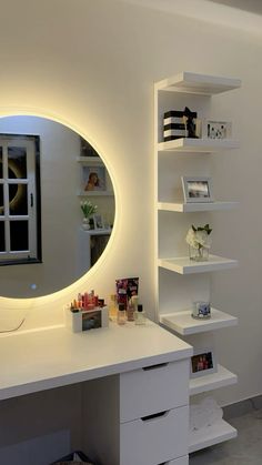 a white desk with a round mirror on the wall and shelving unit behind it