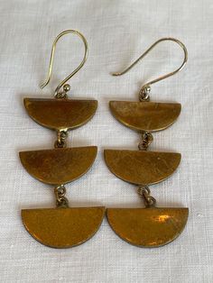 A pair of vintage brass dangle earrings. Cheap Brass Dangle Jewelry, Gold Drop Earrings With Antique Finish, Antique Brass Pierced Earrings, Antique Brass Pierced Plug Earrings, Antique Brass Plug Earrings, Antique Brass Drop Plug Earrings, Antique Brass Plug Drop Earrings, Vintage Gold Hoop Earrings In Brass, Antique Brass Earrings For Pierced Ears