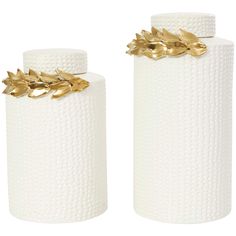 two white vases with gold leaves on them