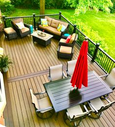 an outdoor deck with furniture and umbrellas on it