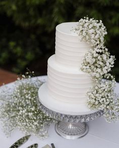 a white wedding cake with baby's breath on top