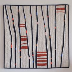 a white wall hanging with black and red lines on it