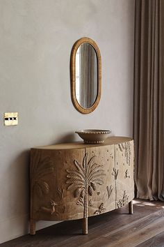 a wooden cabinet sitting next to a window with a mirror on it's side