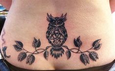 an owl tattoo on the side of a woman's lower back, with leaves around it