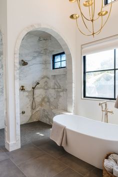 a bathroom with a tub, sink and window