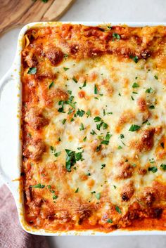 a casserole dish with meat, cheese and parsley