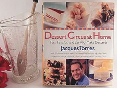 a book about desserts is sitting next to a glass with a spoon in it