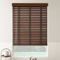 a bathroom with a sink, tub and window blinds in it's windowsill