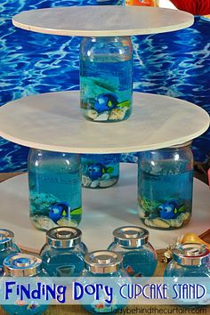 three tiered cake stand with fish in the bottom and blue water below it on display