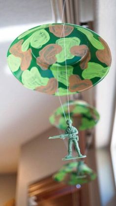 a green and orange paper decoration hanging from a chandelier with an army figure on it