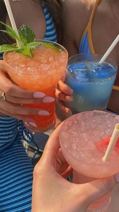 two people holding up drinks in their hands