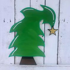 a green metal christmas tree on top of a wooden shelf