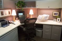 an office cubicle with a computer, printer and file cabinets on the desk in front of it