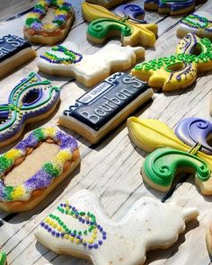 many decorated cookies are on a table with the words mardi gras spelled out