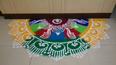 a colorfully decorated floor mat in the middle of a kitchen with white and green designs on it