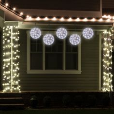 christmas lights are hanging from the side of a house in front of a door and windows