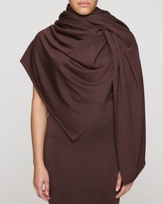 a woman wearing a brown dress with a large shawl